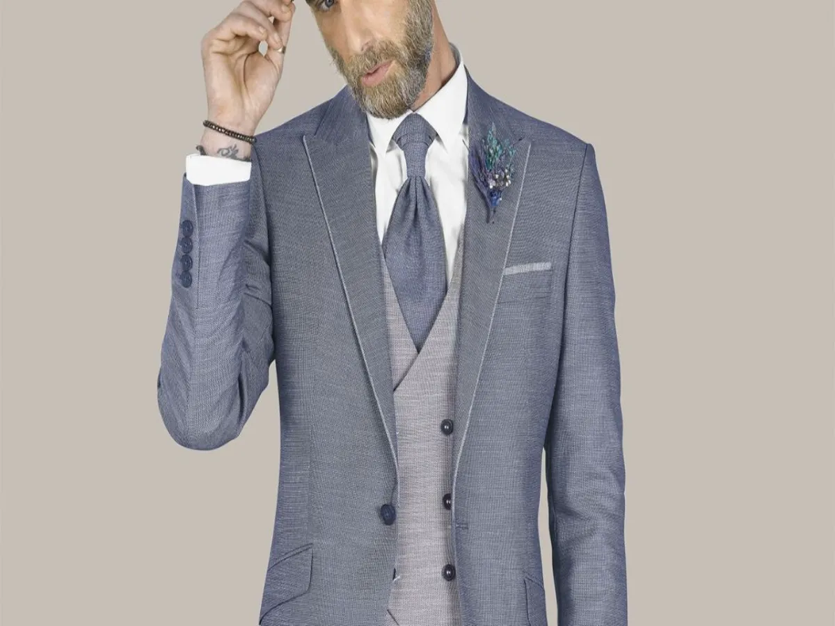 Homem usando terno azul com colete, gravata e flor na lapela, exemplo de dress code social masculino.