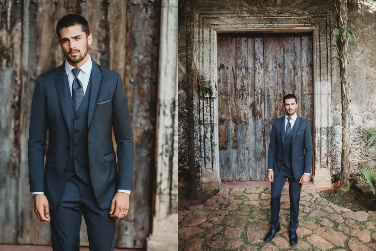 Traje Cerimonial Granite azul-escuro com colete e gravata, usado por modelo em ambiente rústico.